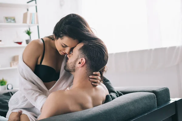 Shirtless and handsome man hugging and kissing with brunette woman in bra — Stock Photo