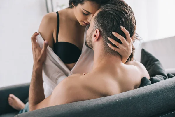 Shirtless man hugging and kissing with brunette and sexy woman in bra — Stock Photo