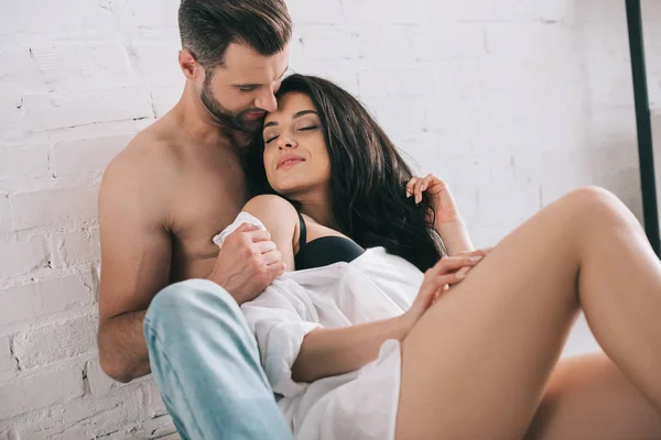 Sexy Mann und attraktive Frau im BH mit geschlossenen Augen umarmen — Stockfoto
