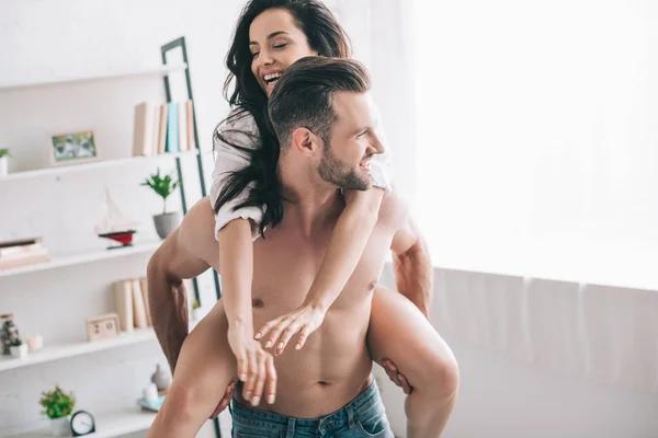 Homem bonito em jeans e mulher sorridente em camisa jogando — Fotografia de Stock