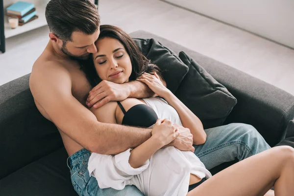 Handsome man and sexy woman with closed eyes in shirt lying and hugging — Stock Photo