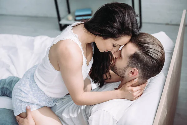 Attractive and brunette woman sitting on man and hugging — Stock Photo