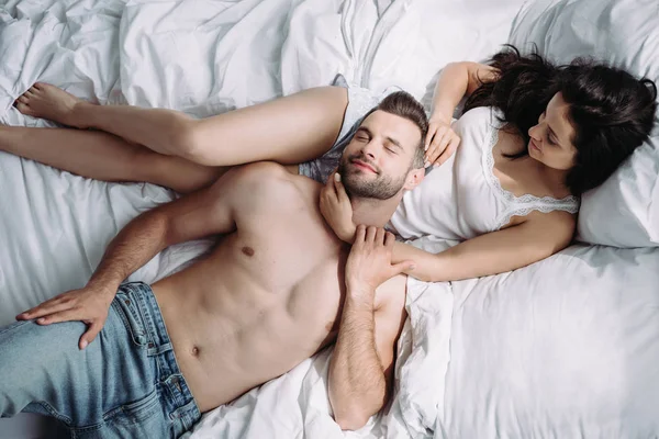 Vue de dessus de bel homme torse nu couché sur la femme attrayante — Photo de stock