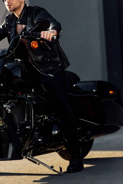 Cropped view of motorcyclist sitting on black motorcycle — Stock Photo