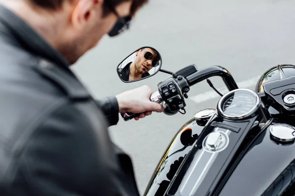 Selective focus of reflection of young man in sungasses sitting on motorcycle — Stock Photo
