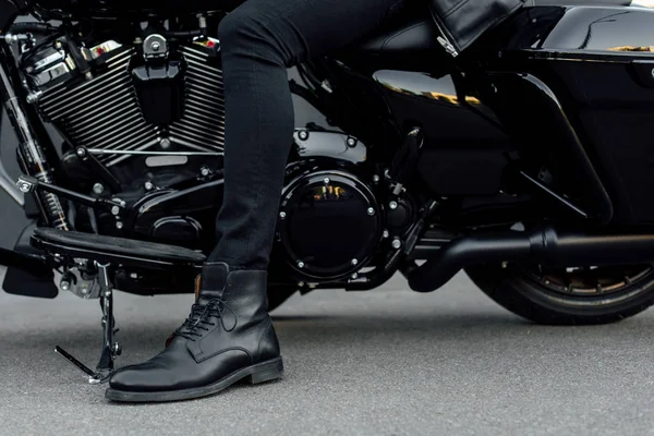 Vista cortada do homem na bota preta sentado na motocicleta — Fotografia de Stock