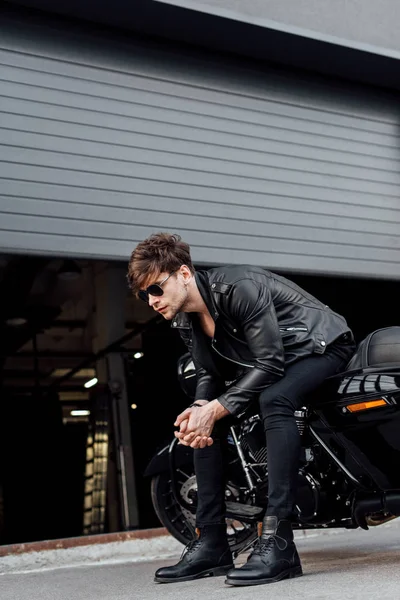 Vue pleine longueur du bel homme assis sur la moto avec les mains serrées et impatient — Photo de stock