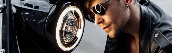 Panoramic shot of handsome man in sunglasses near lamp on — Stock Photo