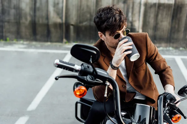 Hombre guapo en chaqueta marrón bebiendo café de la taza de papel - foto de stock