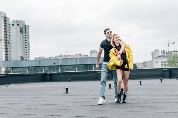 Mujer atractiva y hombre guapo abrazando y mirando hacia otro lado - foto de stock