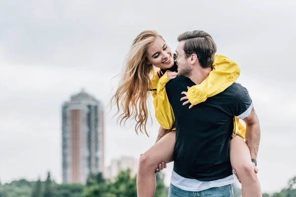 Atractiva mujer y hombre guapo sonriendo y jugando en el techo - foto de stock