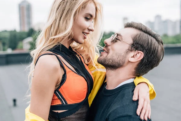 Attraktive und blonde Frau umarmt mit gutaussehendem Mann mit Brille — Stockfoto