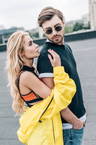 Блондинка і приваблива жінка обіймається з красивим чоловіком в окулярах — стокове фото