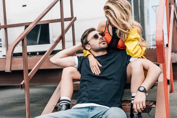 Mujer rubia y hombre guapo en gafas sentado en las escaleras - foto de stock