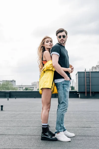 Mujer rubia y atractiva abrazándose con hombre guapo en gafas - foto de stock