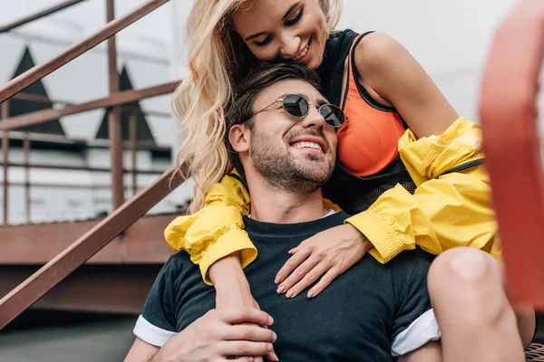 Blonde Frau und schöner Mann mit Brille umarmen sich auf dem Dach — Stockfoto
