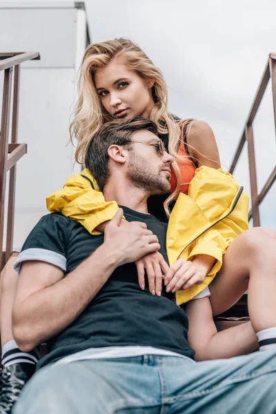 Femme blonde et bel homme dans des lunettes étreignant sur le toit — Photo de stock