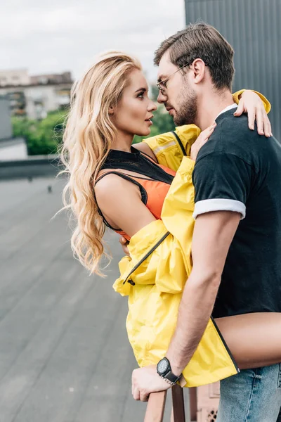 Femme blonde et bel homme étreignant et se regardant — Photo de stock