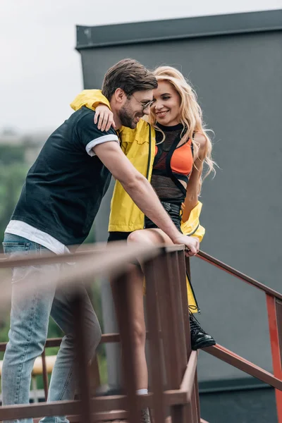 Schöner Mann mit Brille und attraktive Frau lächeln und umarmen auf dem Dach — Stockfoto
