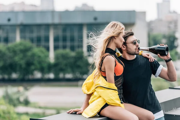 Blonde Frau in gelber Jacke und schöner Mann, der Champagner trinkt — Stockfoto