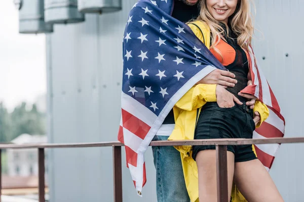 Abgeschnittene Ansicht von Frau und Mann mit amerikanischer Flagge, die sich auf dem Dach umarmen — Stockfoto