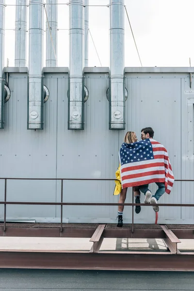 Back view of woman and man with american flag on roof — Stock Photo