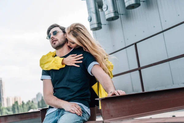 Beautiful and blonde woman kissing and hugging handsome man — Stock Photo