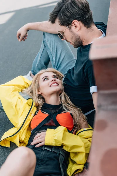 Atractiva mujer y hombre guapo en gafas hablando en el techo - foto de stock