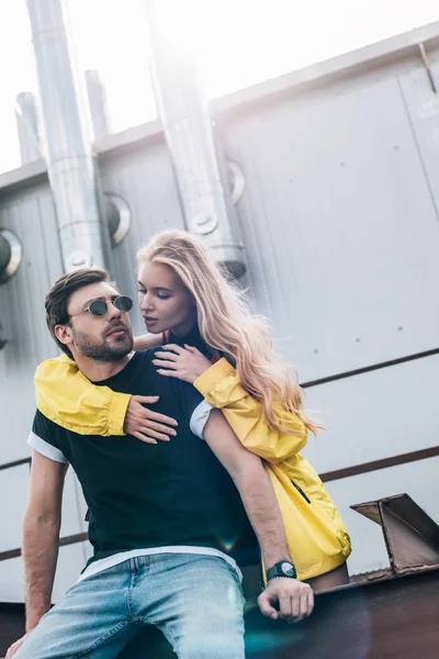 Schöne und blonde Frau umarmt gutaussehenden Mann mit Brille — Stockfoto