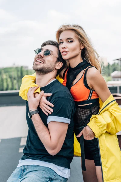 Hermosa y rubia mujer abrazando guapo hombre en gafas - foto de stock