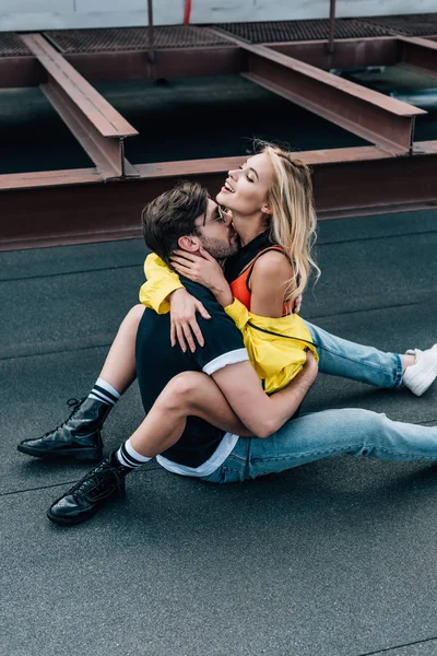 Attractive woman sitting on handsome man and hugging with him — Stock Photo