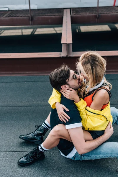 Mulher atraente sentado em homem bonito e abraçando com ele — Fotografia de Stock