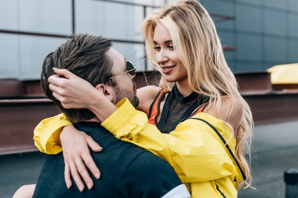 Schöne und blonde Frau umarmt gutaussehenden Mann mit Brille — Stockfoto