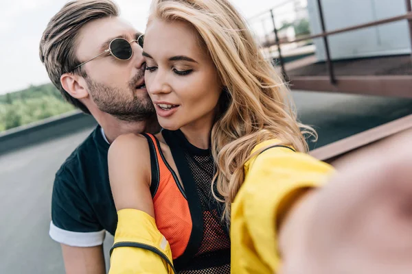 Attraente e bionda donna prendendo selfie con bello uomo — Foto stock