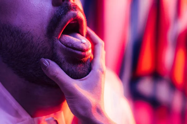 Visão cortada do homem com LSD na língua e mulher tocando seu rosto — Fotografia de Stock