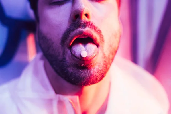 Vue recadrée de l'homme avec les yeux fermés et LSD sur la langue — Photo de stock