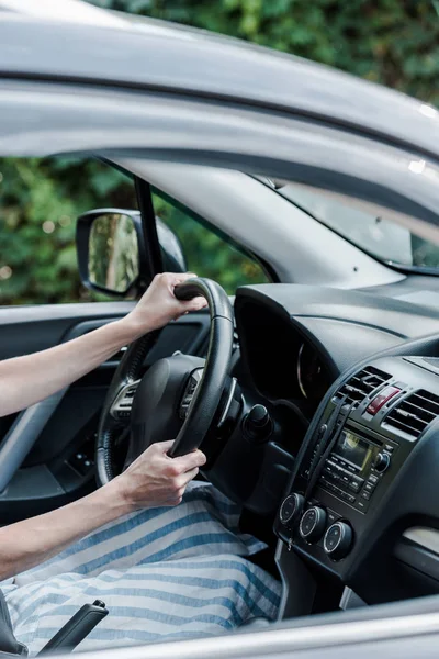 Cropped view of woman driving car and holding steering wheel — Stock Photo