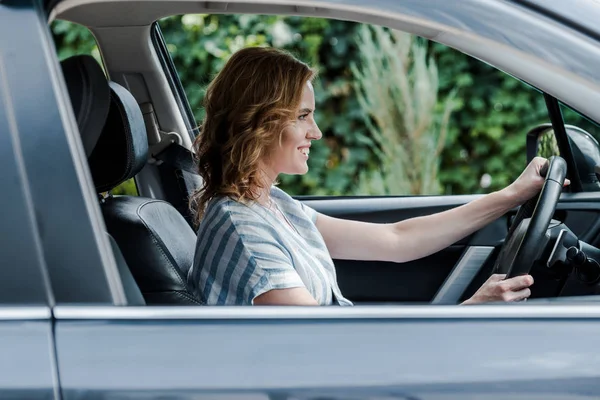 Foco seletivo de mulher loira alegre dirigindo automóvel — Fotografia de Stock