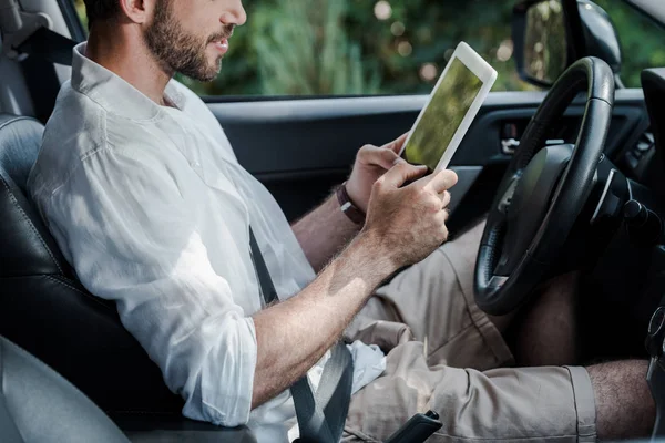 Ausgeschnittene Ansicht eines bärtigen Mannes, der im Auto sitzt und digitales Tablet benutzt — Stockfoto