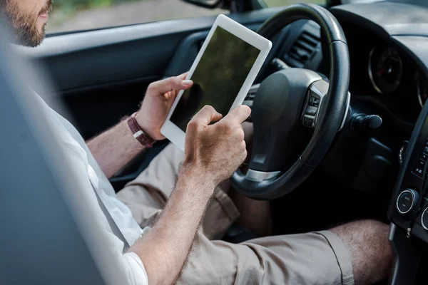 Ausgeschnittene Ansicht eines Mannes, der im Auto sitzt und digitales Tablet benutzt — Stockfoto