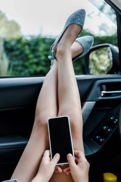 Ausgeschnittene Ansicht von Kind, das Smartphone im Auto hält — Stockfoto