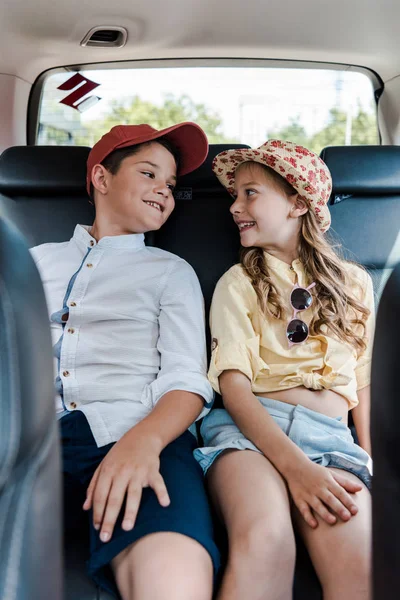 Selective focus of happy kids looking at each other in car — Stock Photo