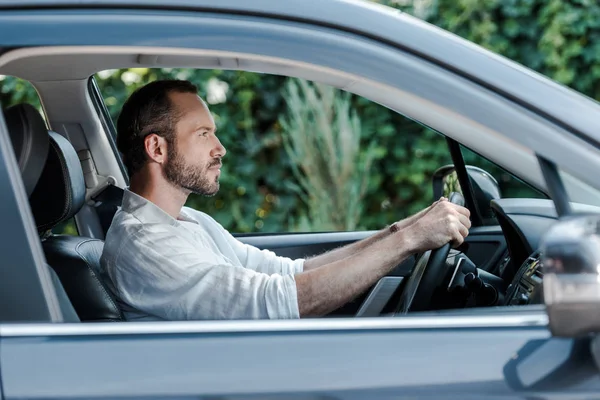 Selective focus of bearded and handsome man driving car — Stock Photo