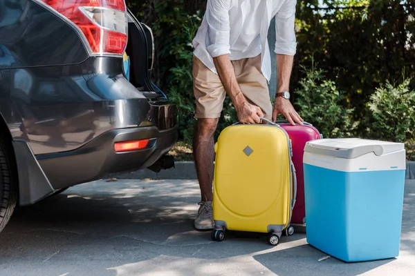 Обрізаний вид чоловіка, що стоїть біля багажу та автомобіля — стокове фото