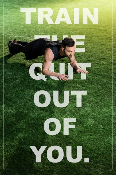 Handsome athletic man doing plank exercise on green grass with train the quit out of you illustration — Stock Photo