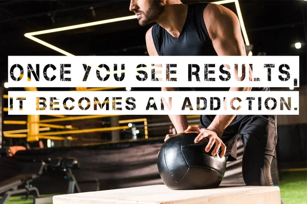 Cropped view of serious man holding ball while standing near squat box with once you see results, it becomes an addiction illustration — Stock Photo