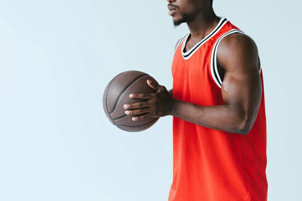 Обрізаний вид афроамериканського спортсмена, що тримає баскетбол ізольовано на сірому — стокове фото