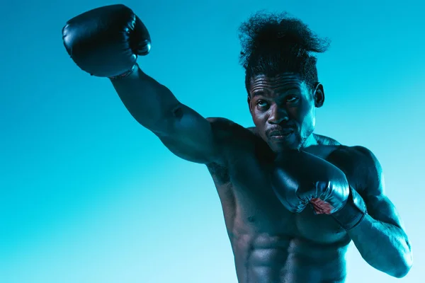 Shirtless african american sportsman with muscular torso on blue background — Stock Photo