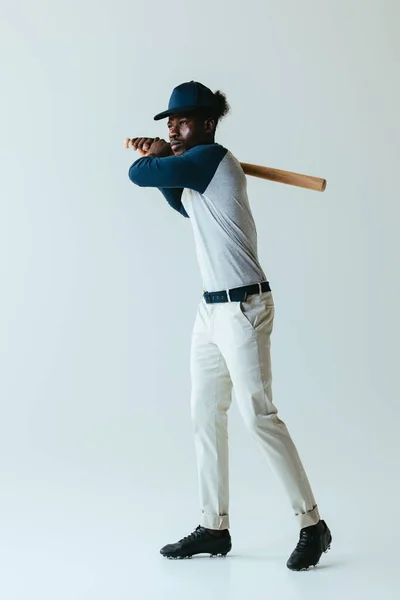 Handsome african american sportsman playing baseball on grey background — Stock Photo