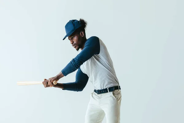 Серьезный африканский американский спортсмен, играющий в бейсбол изолированный на сером — стоковое фото